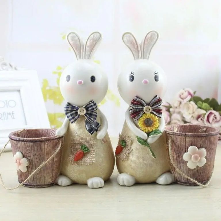 Hermosa decorativo de pareja de conejos con cubeta florales primavera
